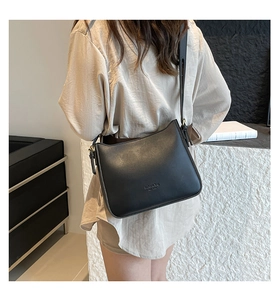 Detail of black leather bucket bag featuring gold fashion bag New York lettering