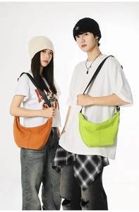 Neutral bright orange and green crescent crossbody bags worn by models in studio
