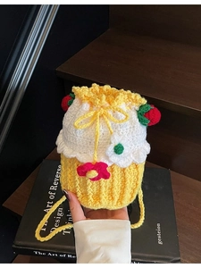 Handmade crochet strawberry bucket bag with floral patterns and yellow woven strap