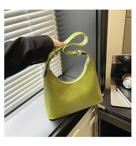 Close-up of avocado green matte leather hobo bag with silver metal hardware accents