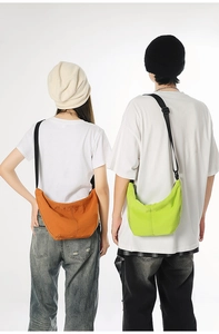 Back view showing orange and neon green crossbody crescent bags with adjustable straps