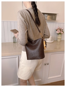 Détail du sac seau marron café avec gland en perles de bois colorées et finitions dorées