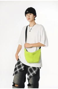 Fluorescent green crossbody crescent bag with adjustable strap worn by model