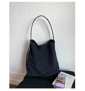 Gros plan du grand sac cabas en nylon noir avec détail d'étiquette rose de style décontracté