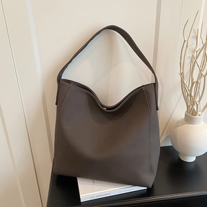 Bolso tote minimalista de cuero marrón chocolate con acabado mate en un entorno moderno