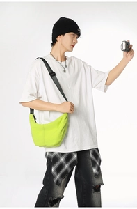 Detail of neon green crescent bag featuring textured nylon fabric and black zipper
