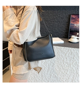 Detail of matte black leather bucket bag with fashion bag NEW YORK embossed lettering