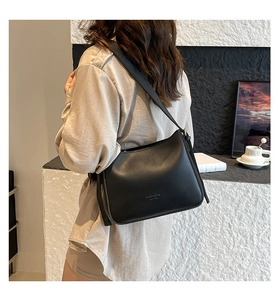 Minimalist black leather hobo bag featuring NEW YORK text detail in a cozy urban setting