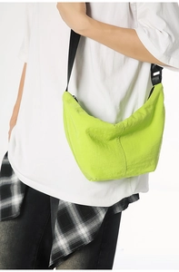 Detail of neon green nylon dumpling bag with black adjustable wide shoulder strap