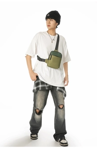 Vorderansicht einer olivgrünen Crossbody-Brusttasche an einem Model im hellen Studio