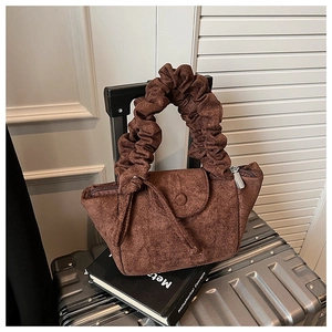Detail shot of pleated suede handle and soft chocolate brown fabric texture