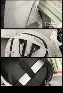 Detail of reinforced straps, handle, and padded laptop compartment in light gray backpack