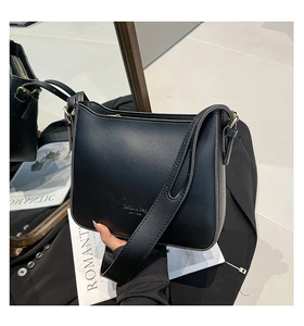 Detail of black textured bucket bag with fashion bag lettering and golden buckle