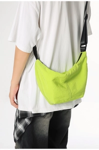Detail of neon green crossbody bag with durable nylon fabric and adjustable strap