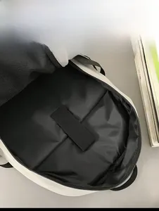 Internal view showing a padded laptop compartment with a velcro strap in a white backpack