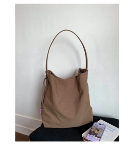 Détail d'un grand sac fourre-tout marron avec cordon latéral et texture gaufrée