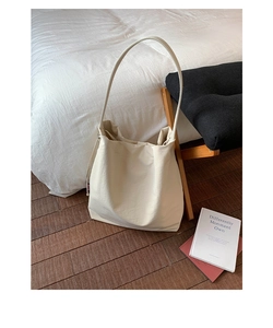 Vue détaillée du sac fourre-tout en toile crème sur une chaise montrant son design épuré