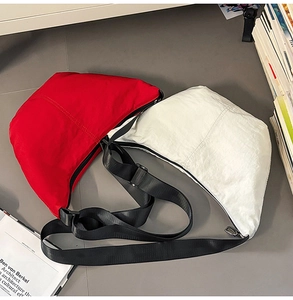 Flat lay view of durable nylon crescent crossbody bags in red and white colors