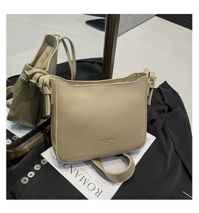 Detail of khaki leather bucket bag with gold zipper and New York lettering on the surface