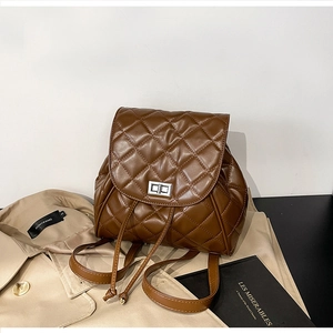 Close-up of quilted brown leather backpack with silver twist lock and drawstring detail