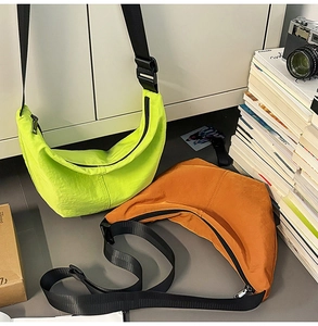 Close-up of lightweight nylon crescent bags in lime green and caramel with wide straps