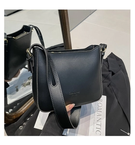 Detail of black faux leather crescent bag with adjustable wide strap and gold hardware