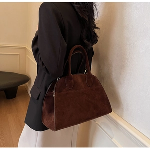 Détail du sac cabas en daim marron foncé avec poignées élégantes en situation réelle