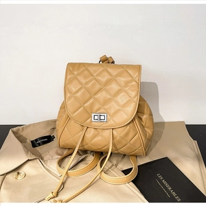 Detail of light brown quilted backpack with silver clasp and Les Misérables book