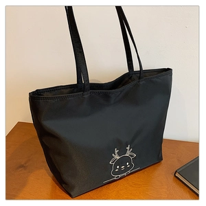 Detail view of black nylon tote bag with cute white deer print and long handles