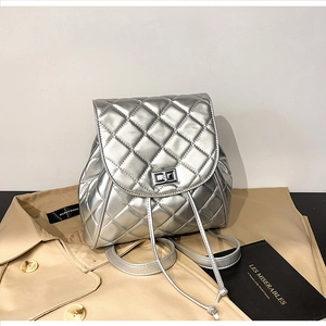 Detail view of the silver quilted leather backpack with metallic finish and turn-lock closure