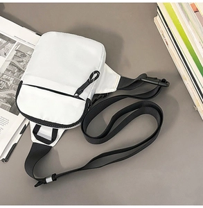 Detailansicht der weißen Canvas-Brusttasche mit schwarzem Reißverschluss und Nylonband