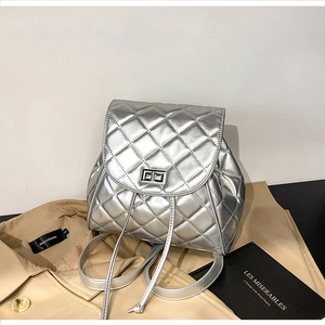 Detail of silver quilted backpack with metallic finish and rectangular turn-lock closure