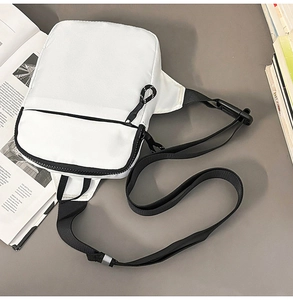 Minimalistische weiße Brusttasche aus Nylon mit schwarzem Gurt auf Lifestyle-Hintergrund