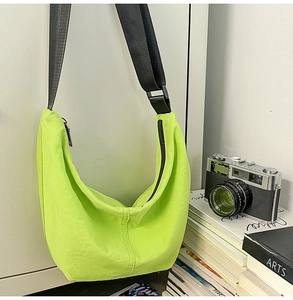 Close-up of lightweight neon green nylon crescent bag with adjustable black strap