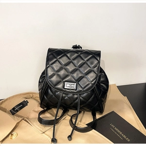 Detail of black quilted leather backpack featuring silver twist lock and drawstring closure