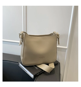 Detail of matte PU leather bucket bag in beige with adjustable strap and metal hardware