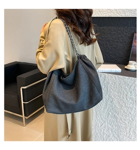 Large capacity washed grey denim tote bag with chain strap worn by a model