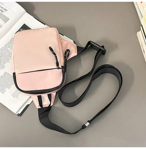 Draufsicht auf die pinke Brusttasche mit Reißverschlussfächern auf einem grauen Schreibtisch