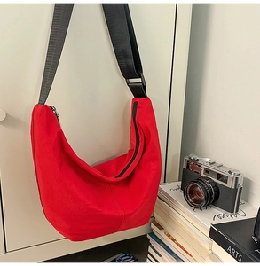 Detailed shot of large red nylon hobo bag featuring black wide adjustable shoulder strap