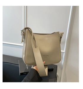 Detail view of khaki half-moon bucket bag featuring fashion bag NEW YORK text
