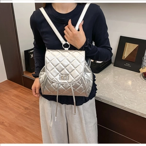Detail view of a silver quilted diamond pattern mini backpack with metal chain straps