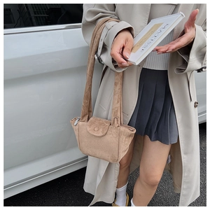 Macro shot of brown suede texture on a stylish pleated handbag with long straps