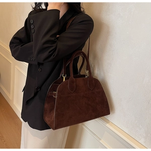 Détail d'un grand sac cabas vintage marron foncé avec finitions dorées et bandoulière