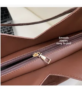 Close-up of smooth gold zipper and pebble leather texture on a brown tote bag