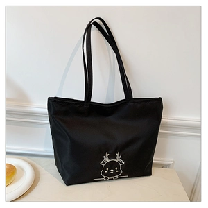 Detail of black nylon tote bag with white cartoon deer print and dual handles