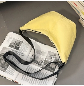 Macro shot of the lightweight yellow nylon messenger bag on an architectural magazine