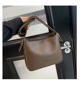 Detailed view of the dark brown bucket bag with fashion bag NEW YORK text and strap