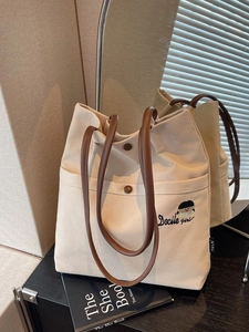 Minimalist canvas tote bag with brown leather handles and Docile girl embroidery