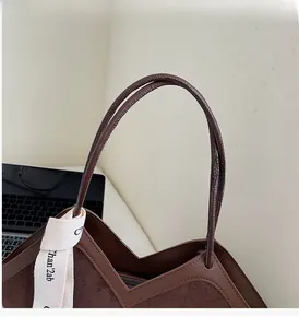 Detail view of brown matte suede and smooth leather tote bag with cotton strap