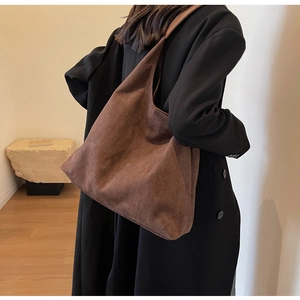 Detail of dark brown suede shoulder tote bag with a minimalist hobo silhouette